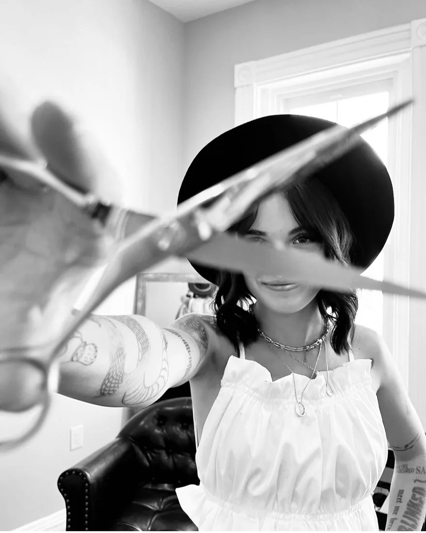 A barber holding scissors up toward the camera